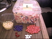 Container of multi-colored beads for use in activity to study elemental abundances