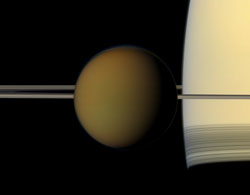 Titan, passes in front of Saturn and its rings