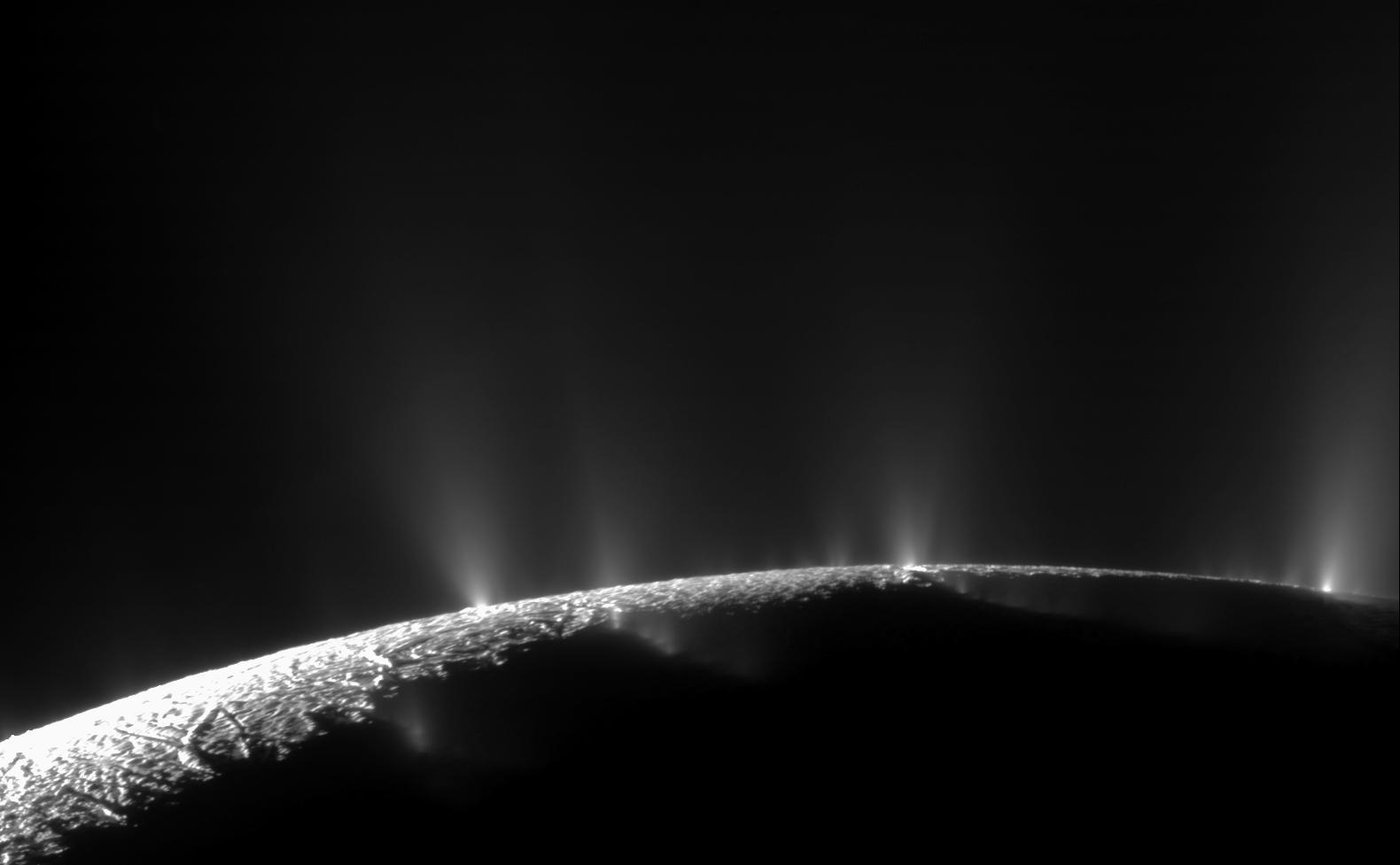 Black and white image of jets of material blasting off Enceladus.