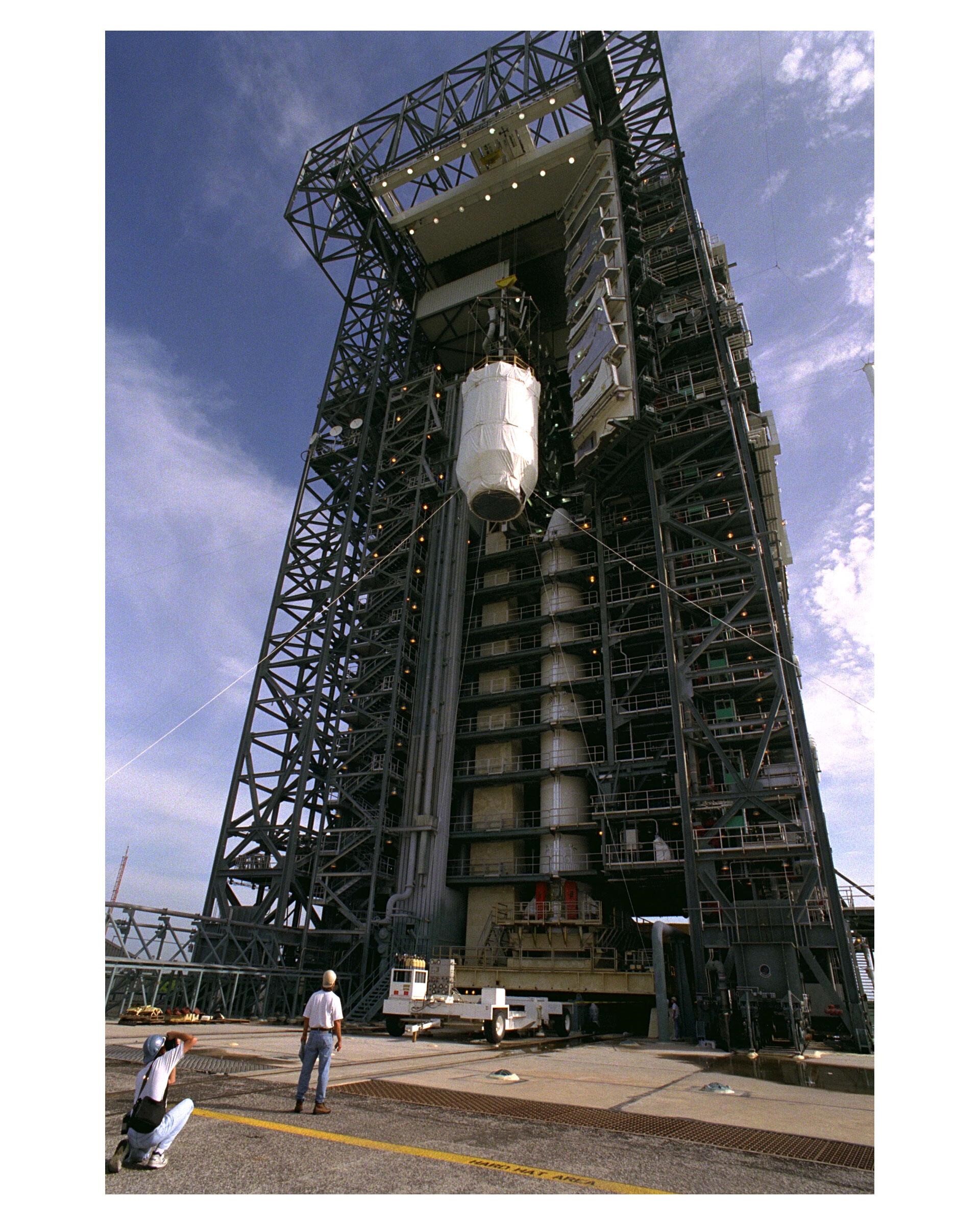 Color image of rocket upper stage being lifted atop rocket.