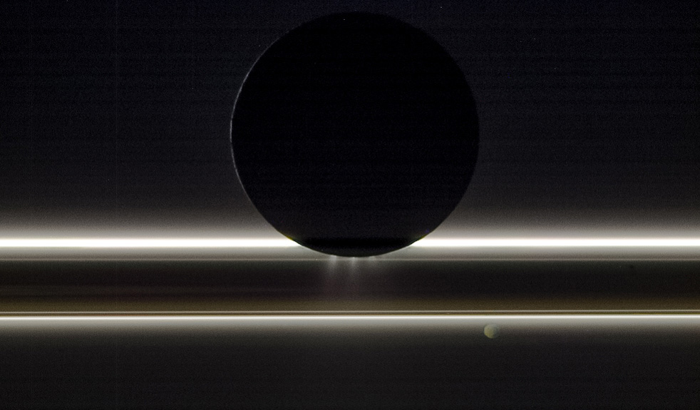 Enceladus and Saturn's rings illuminated by sunlight.
