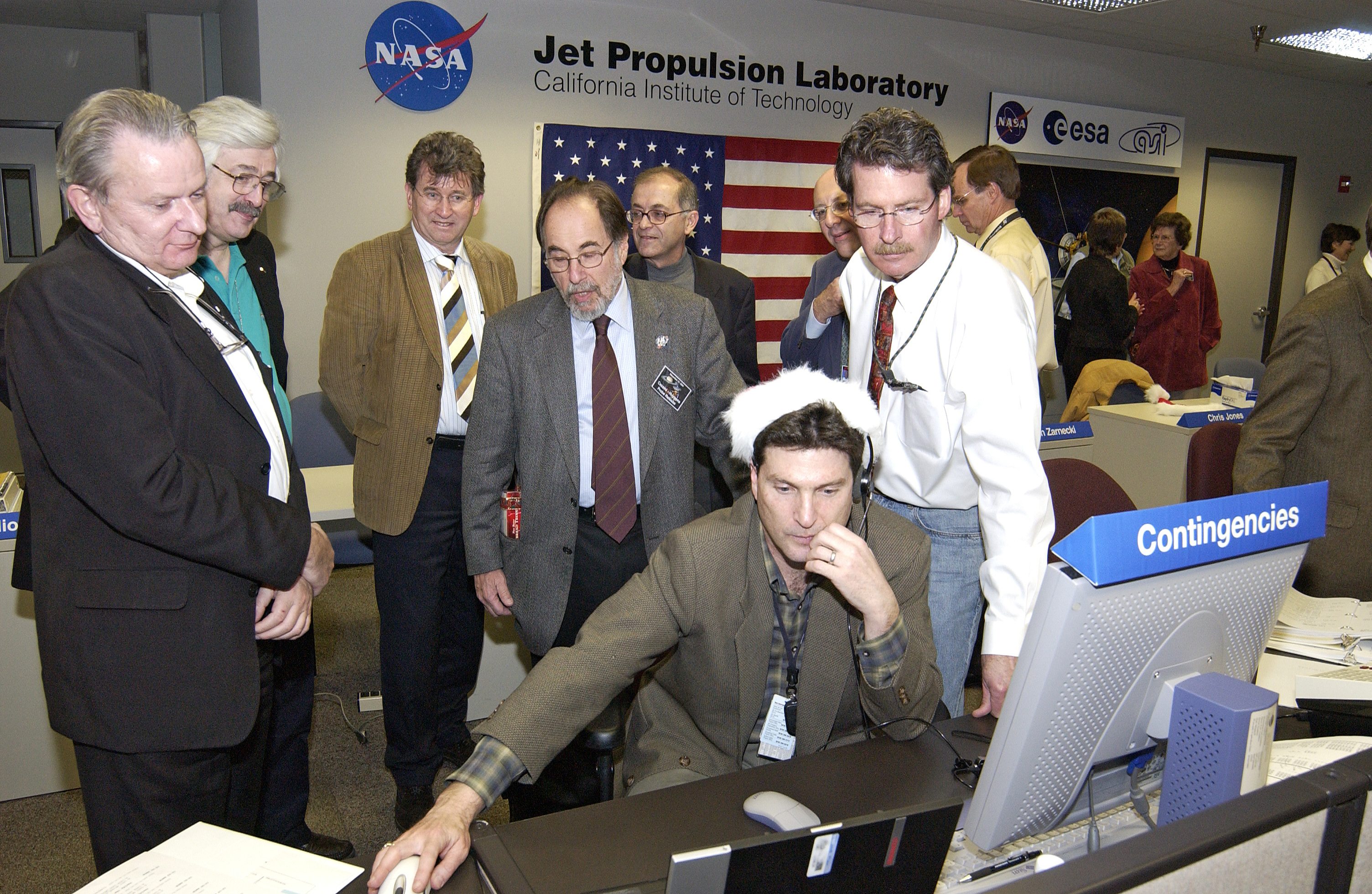 Group of men gathered at console.Credit: NASA/JPL-Caltech