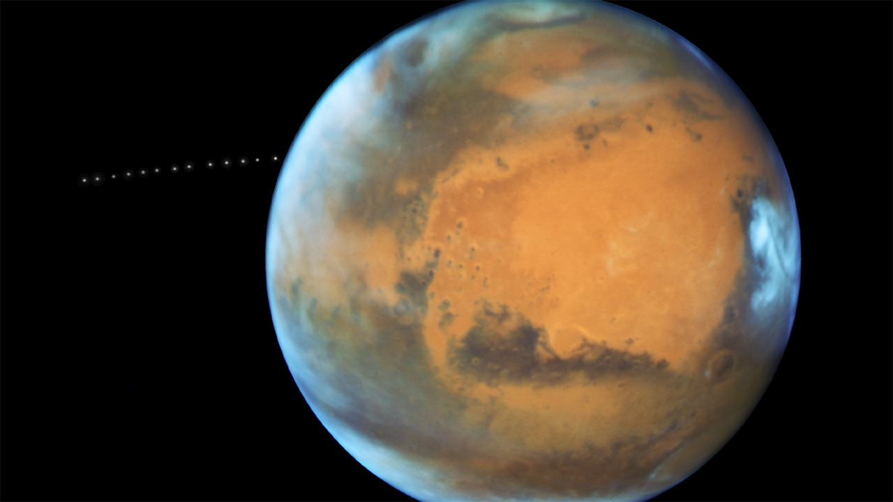 Sequence showing small moon orbiting Mars.