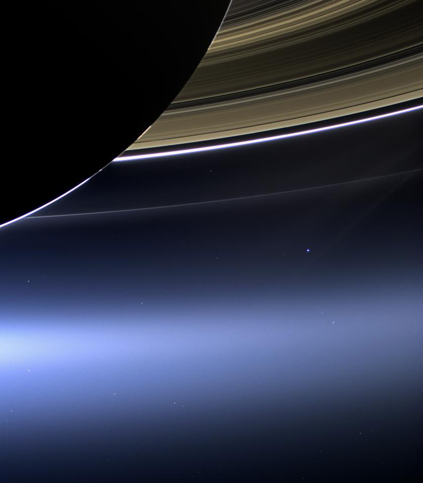 Saturn with Earth as a small dot in the distance.