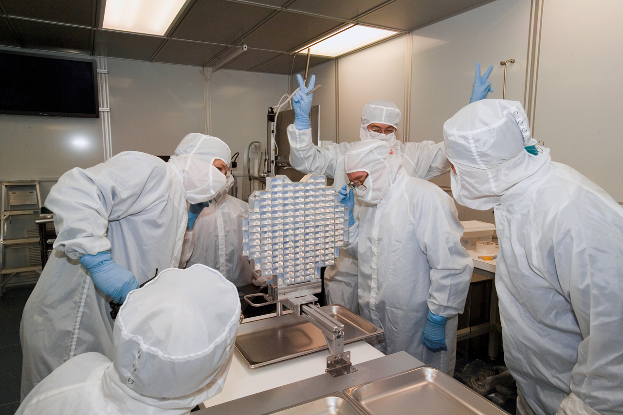 Mensen in cleanroom rond monsterverzamelinstrument.