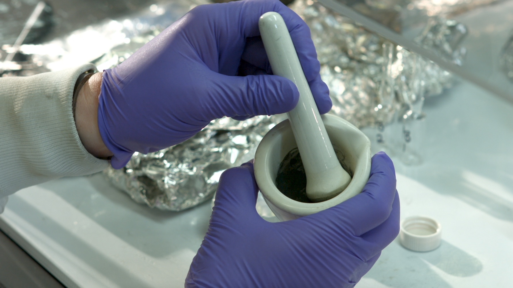 Grinding a sample with mortar and pestle.