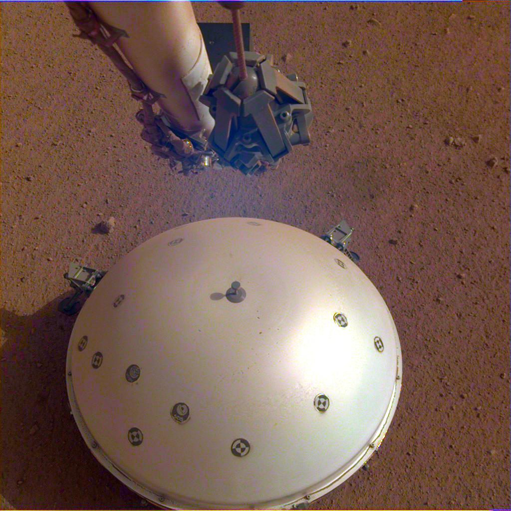 mechanical arm and smooth dome on reddish surface