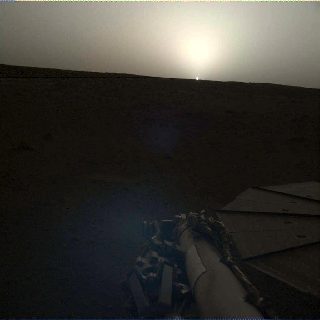 Sun setting on dusty horizon of Mars.