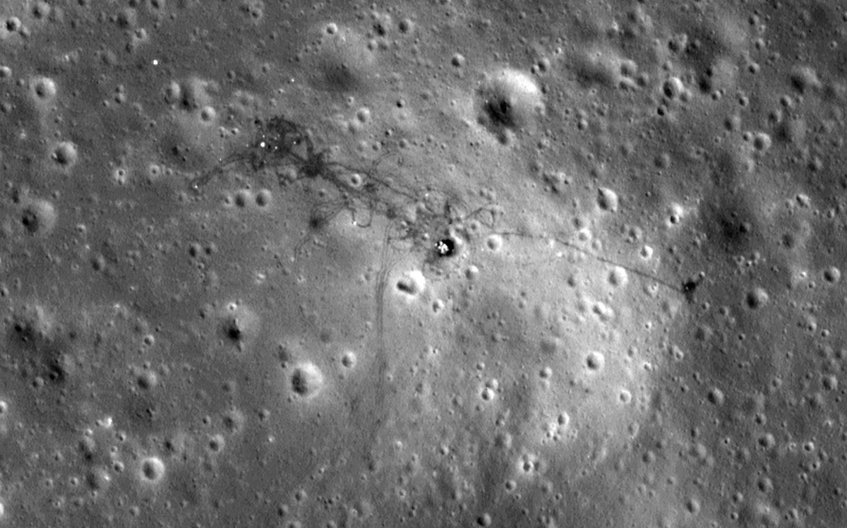 plain viewed from above with craters, spacecraft and foot trails visible