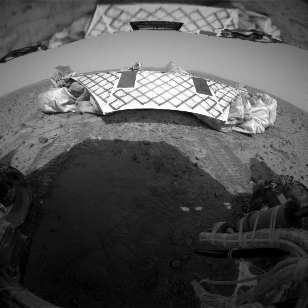 Image of landing platform on Mars with rover wheel tracks in foreground.