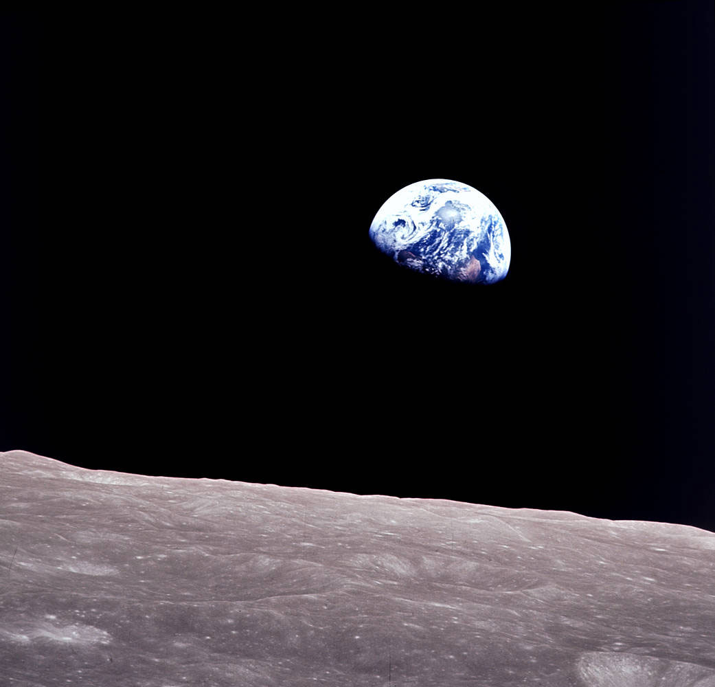 Earth rising above the cratered surface of the Moon.