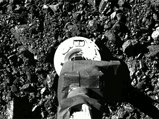 Close up of OSIRIS-REx arm touching the surface of Bennu.