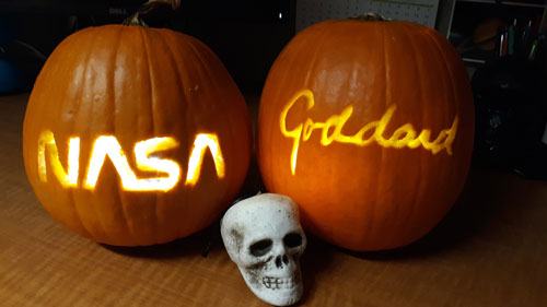 Two pumpkins carved with NASA designs.