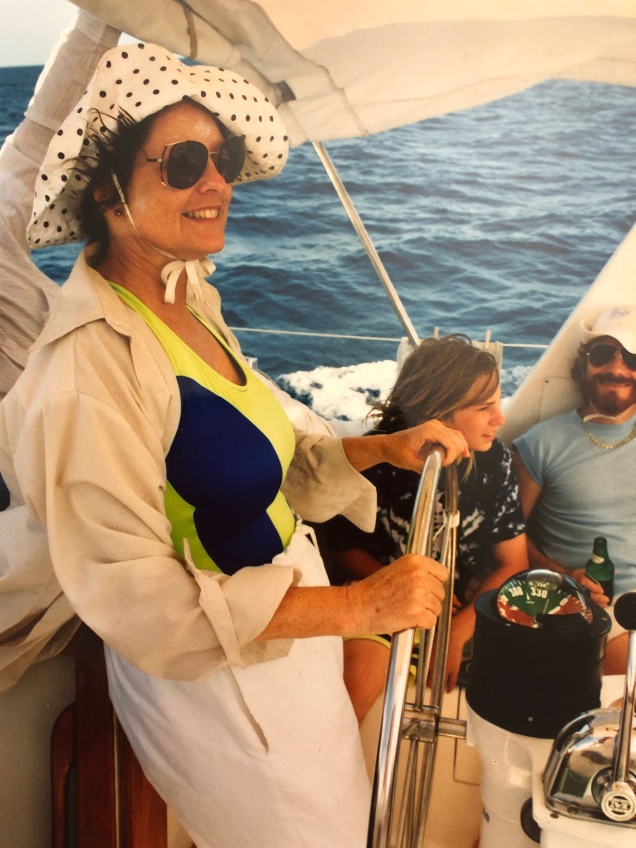 Lori Glaze's mother at the helm of a sailboat.