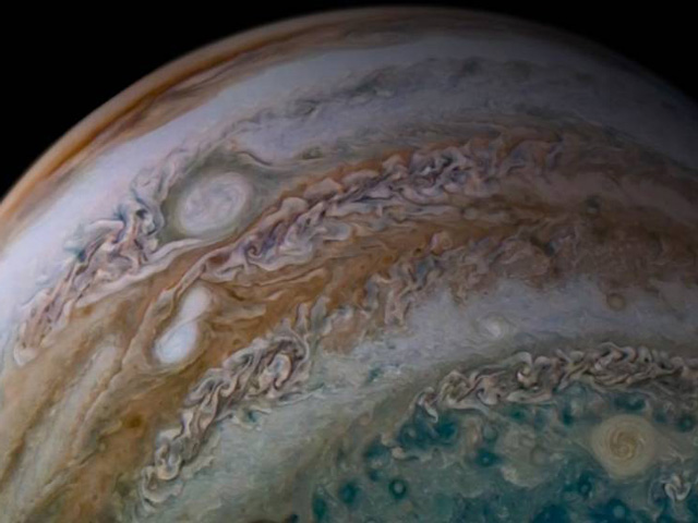 This view from the JunoCam imager on NASA’s Juno spacecraft shows two storms merging