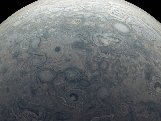 swirling storms visible near the top of Jupiter's atmosphere
