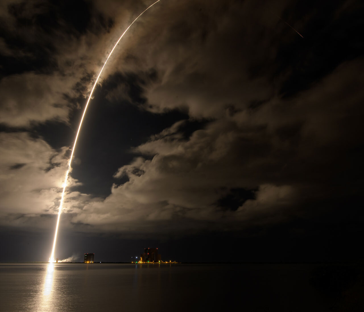 A rocket leaves an arching trail of light at it launches into space from the Florida coast.