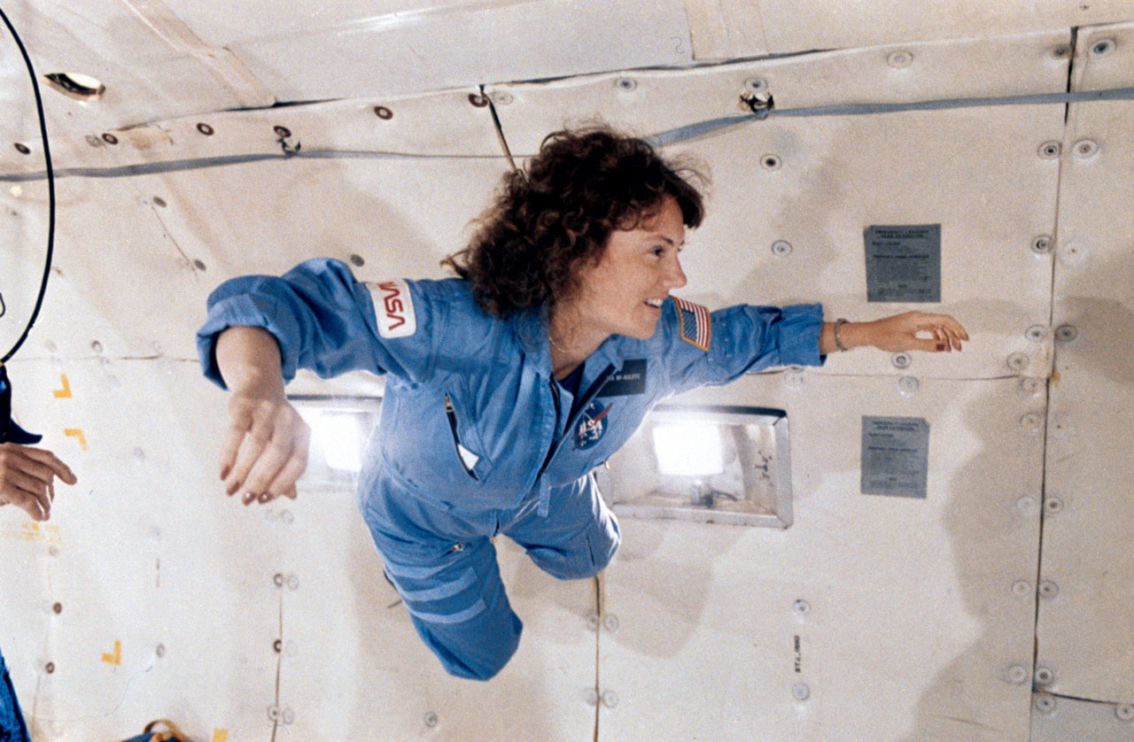 Christa McCauliff smiles as she floats the cabin of a zero-G similar aircraft.