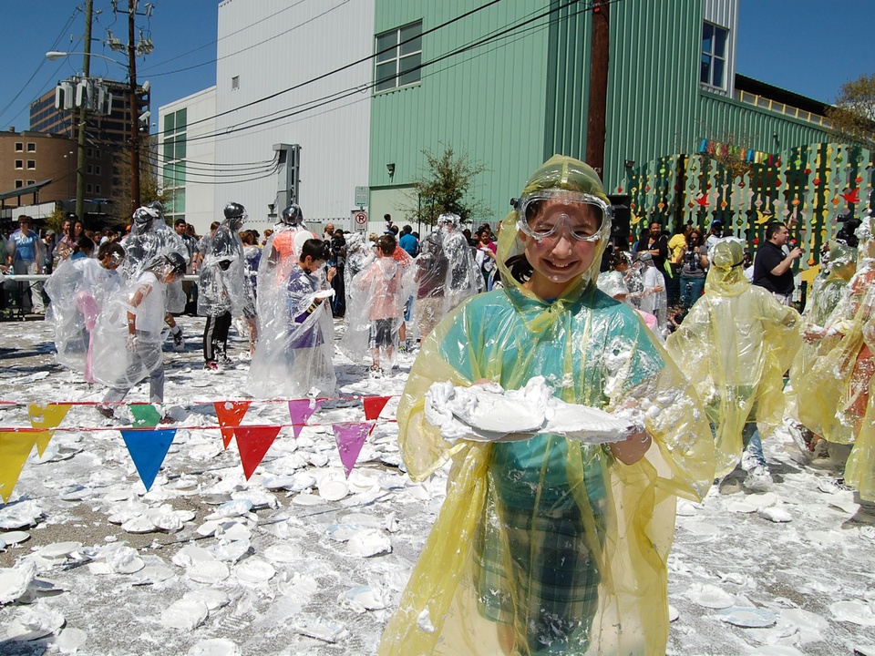 Girl in rain poncho holding pie after pie fight.