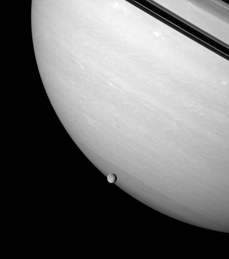 Rhea brushes the stormy face of Saturn