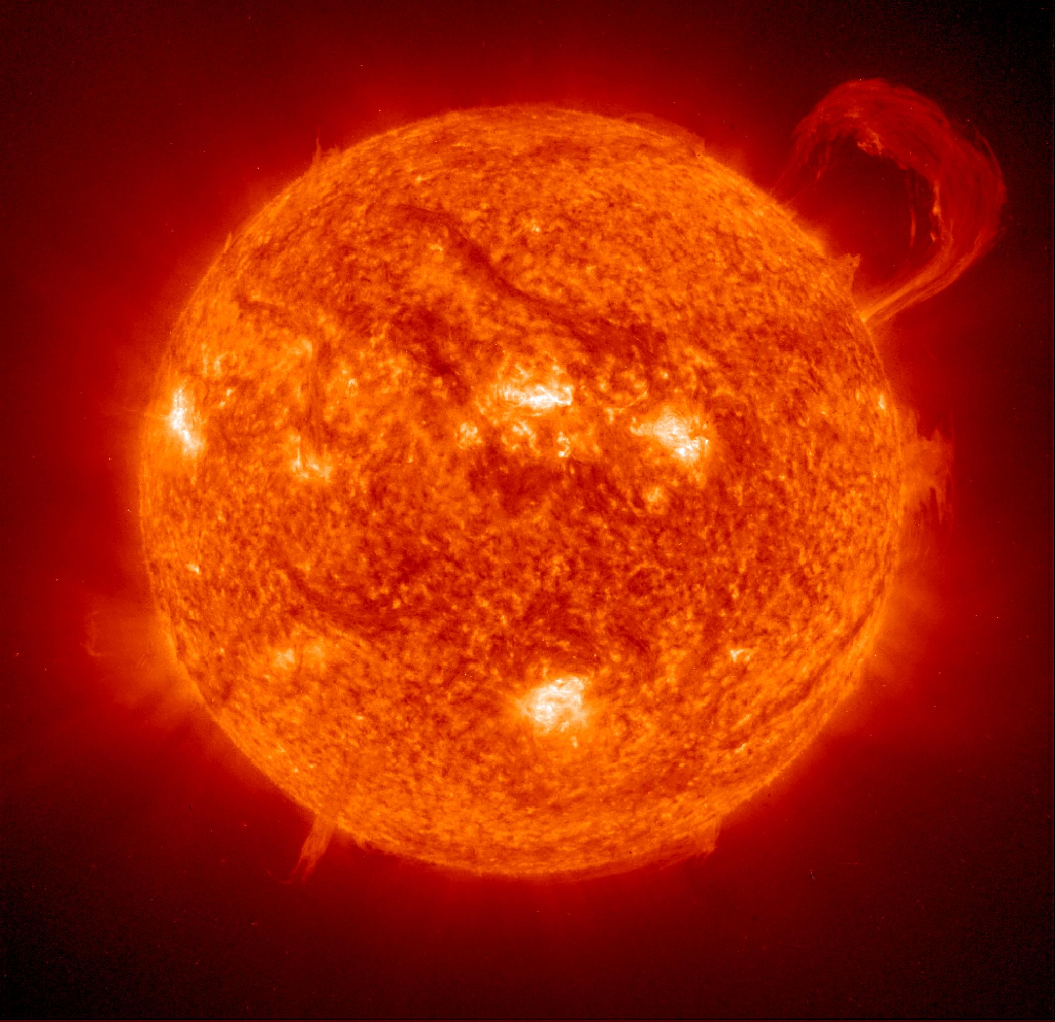 Large handle of glowing plasma extending from the Sun.