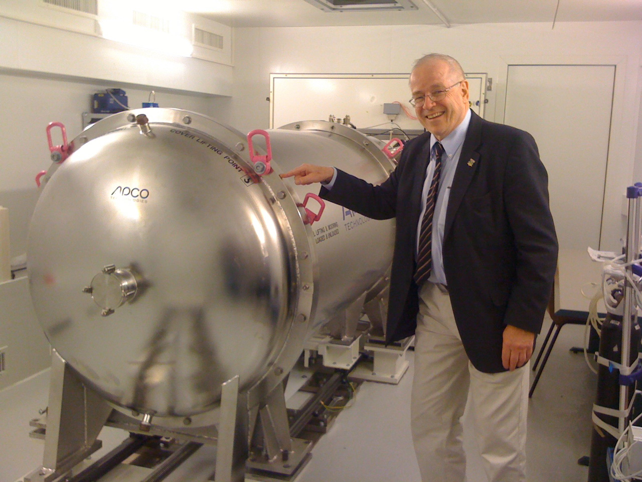 A man is seen with a giant steel tank holding an instrument within.
