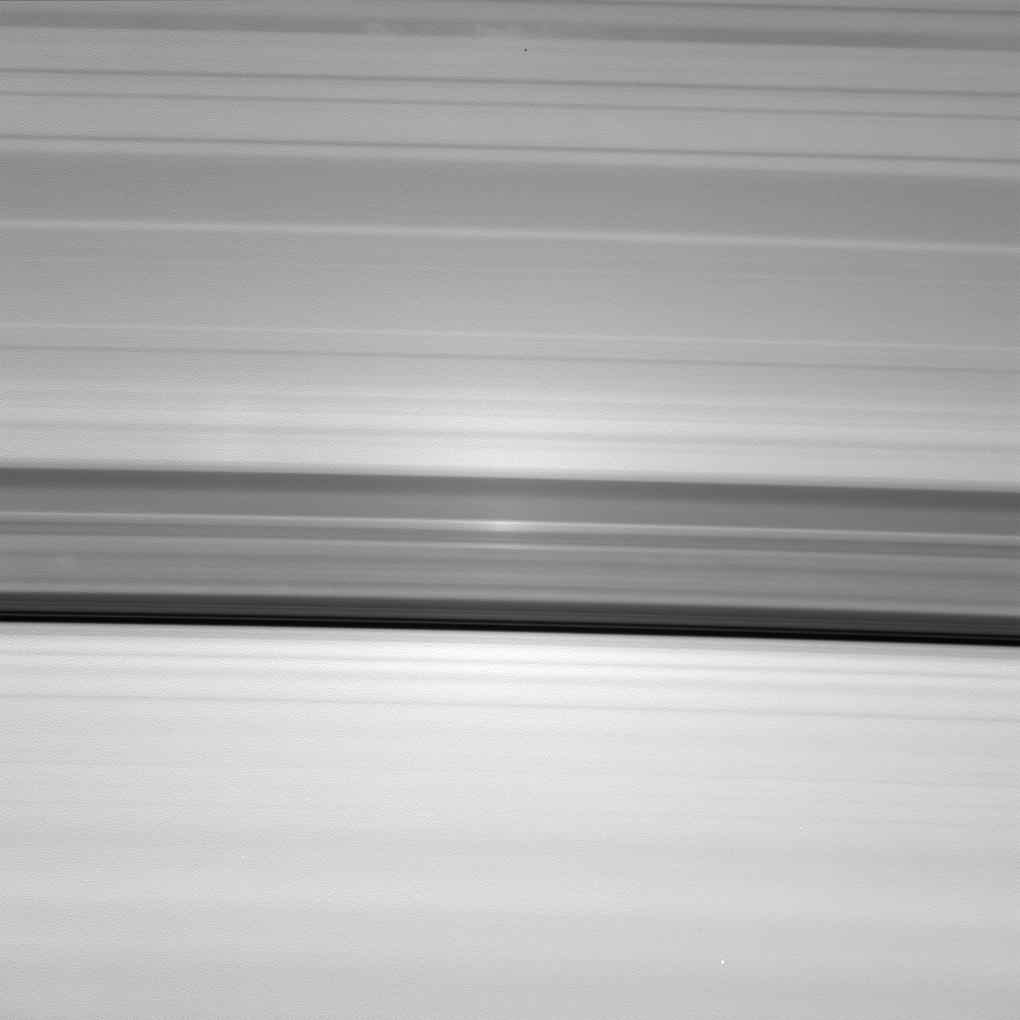 A brilliant spot of sunlight travels outward across the rings