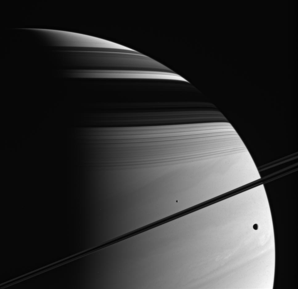 Tethys (at the right) and Mimas (near the center) are captured in this imag against Saturn's turbulent atmosphere. 