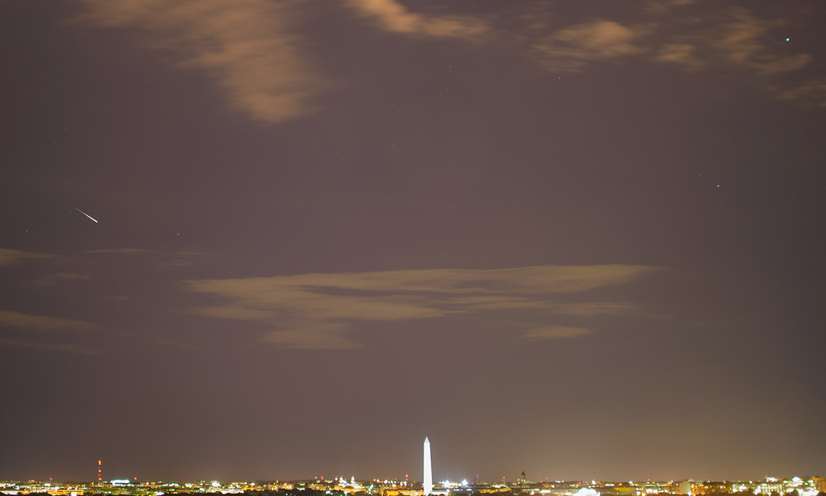 In this ten-second exposure, a meteor streaks across the sky above Washington, DC during the annual Perseid meteor shower, Thursday, Aug. 13, 2015, in Arlington, Va.