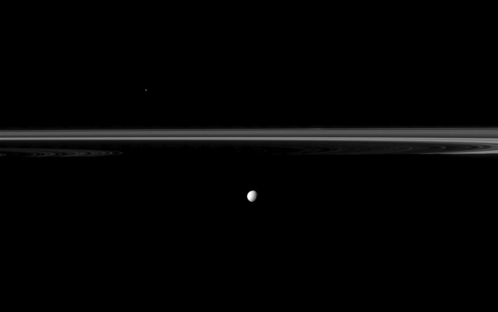Saturn's moon Mimas joins the planet's rings which appear truncated by the planet's shadow in this Cassini spacecraft image.
