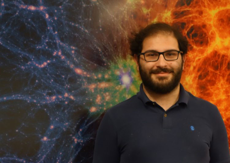 Steven Silverberg standing in front of a galactic background of stars and colorful swirls of gas.