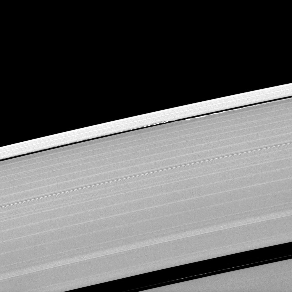 A scalloped look is created in the edges of the Keeler Gap in Saturn's outer A ring as the moon Daphnis orbits in the gap.