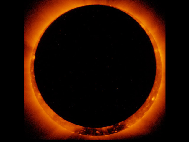 A slightly off center black circle almost completely covers an orange Sun, creating a ring of fire effect