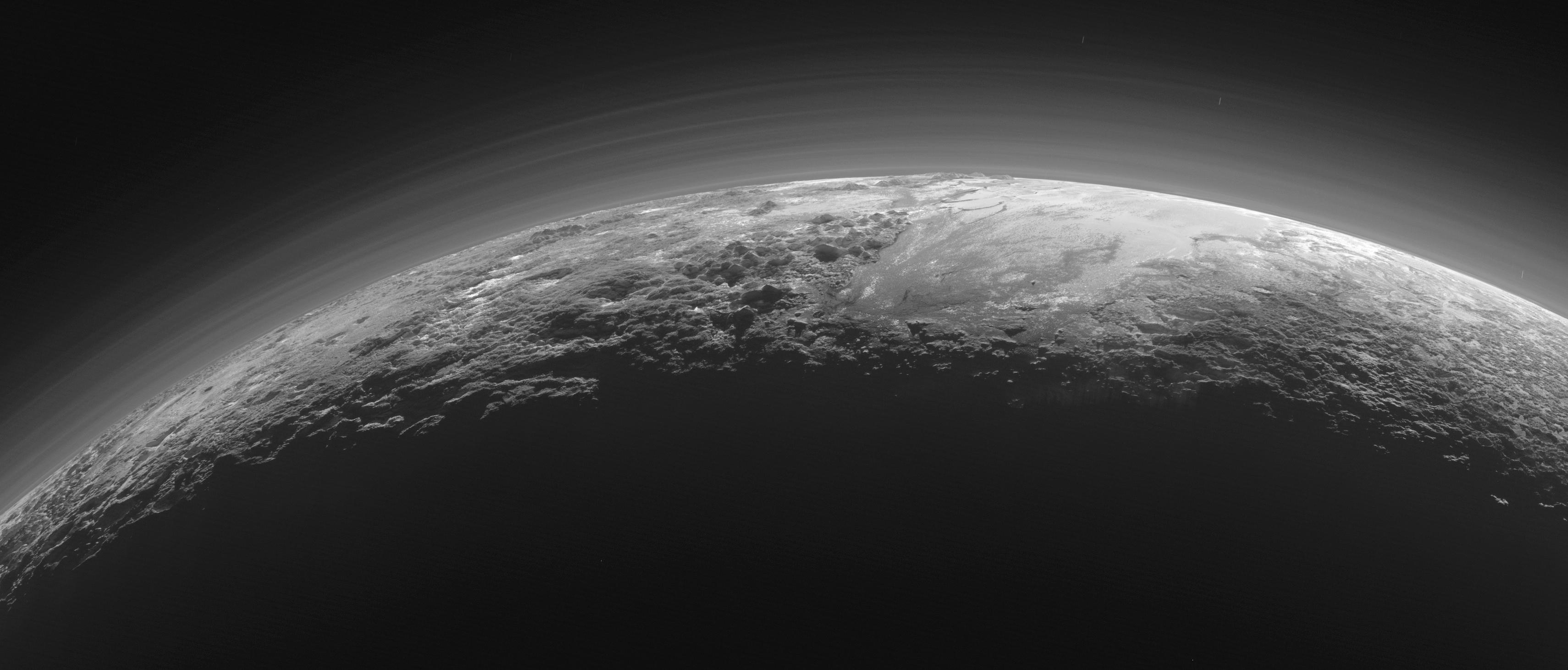 Just 15 minutes after its closest approach to Pluto on July 14, 2015, NASA's New Horizons spacecraft looked back toward the sun and captured this near-sunset view of the rugged, icy mountains and flat ice plains extending to Pluto's horizon.