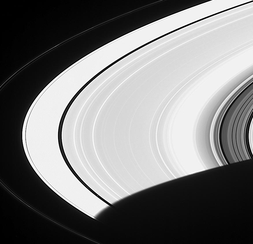 Pan is a faint speck in a gap in the wide expanse of Saturn's ring.