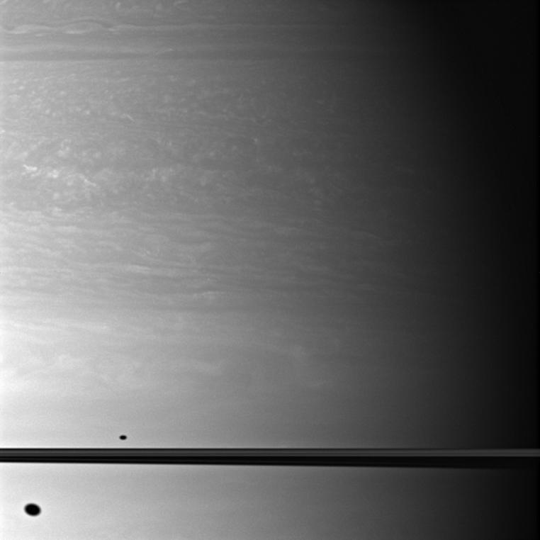 The shadows of Dione and Mimas appear on Saturn