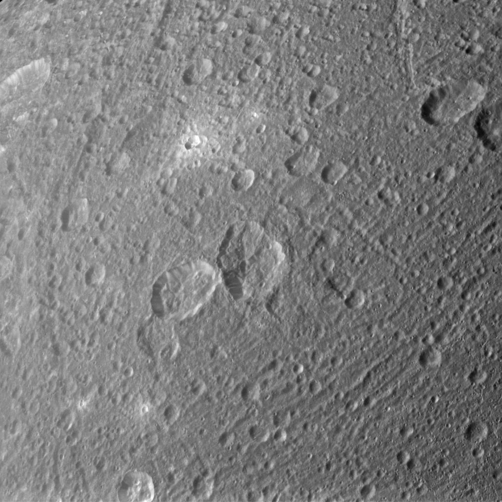 Ejected material appears bright around some of Dione's craters