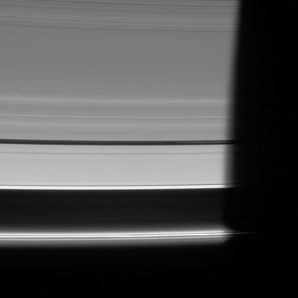 The unlit side of the rings, the small moon Pan heads into Saturn's shadow