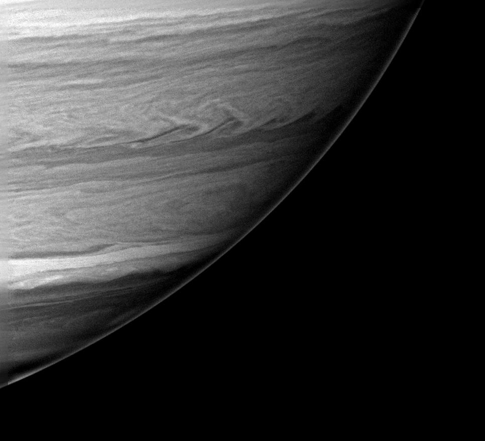 Black and white image of one-quarter of Saturn showing swirling cloud formations.