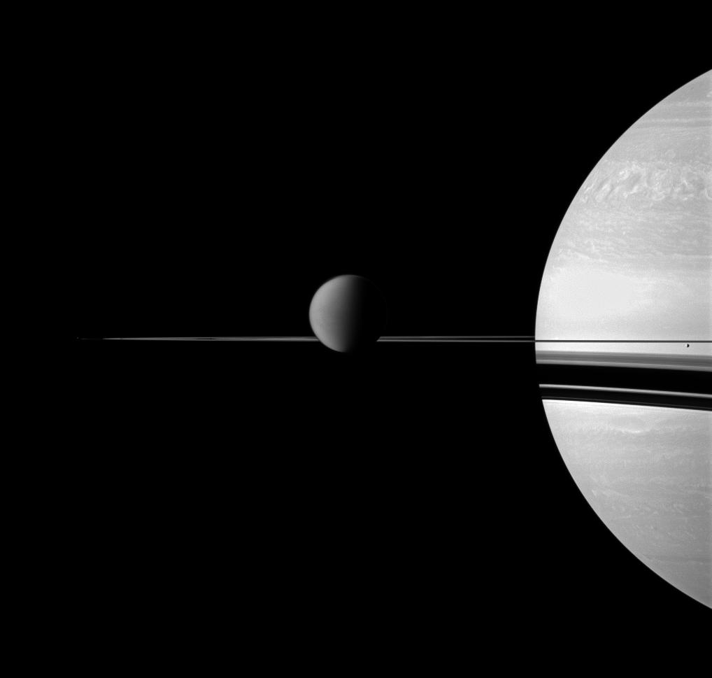 The Cassini spacecraft views Saturn with a selection of its moons in varying sizes.