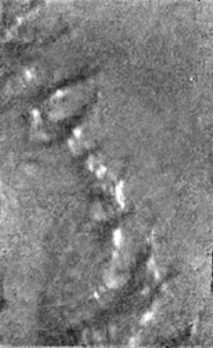 Black and white image of bright spots on the surface of Titan seen from above.