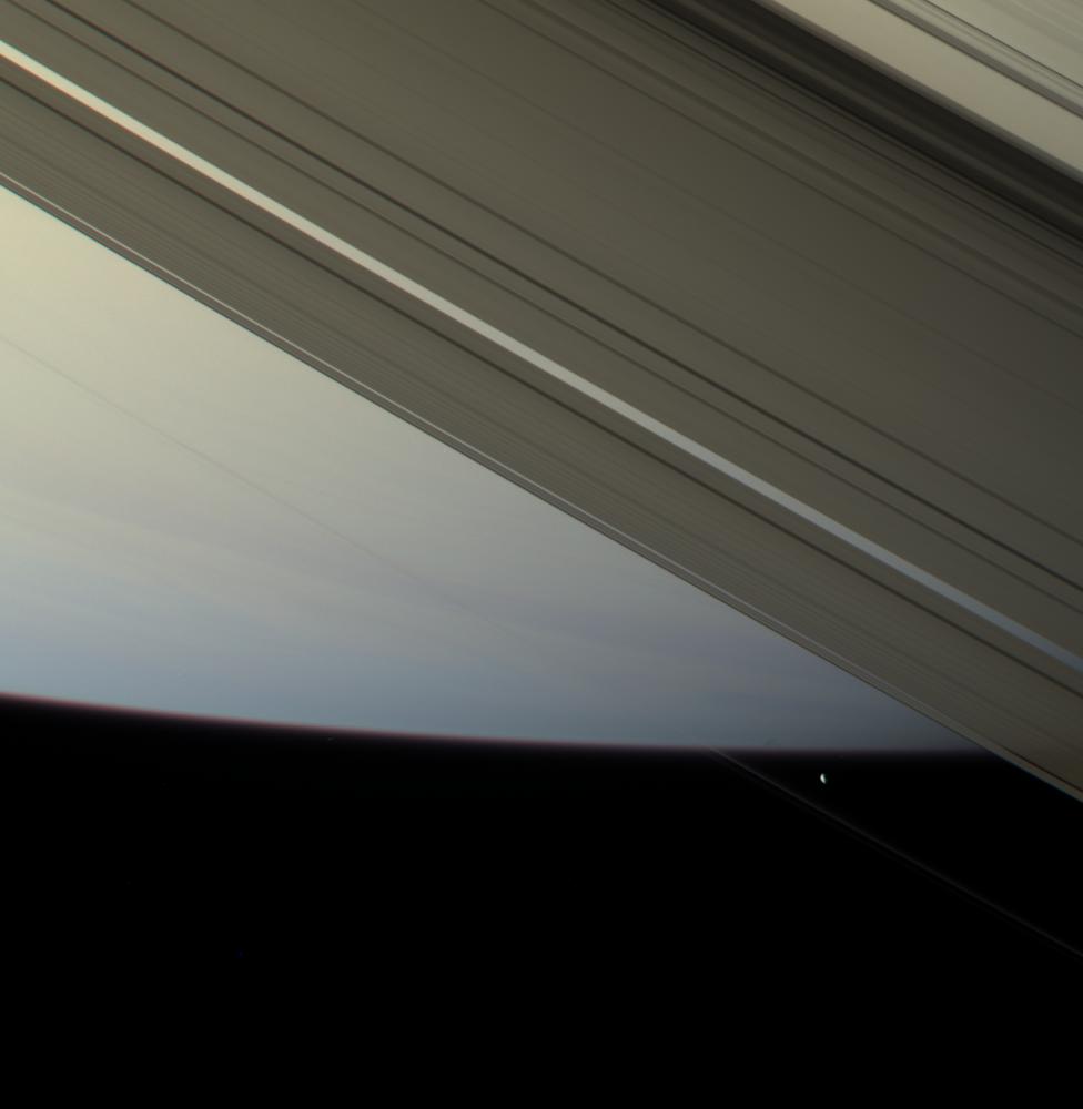 The F ring shepherd moon Prometheus touches the face of Saturn once more before moving off into blackness and continuing in its orbit.