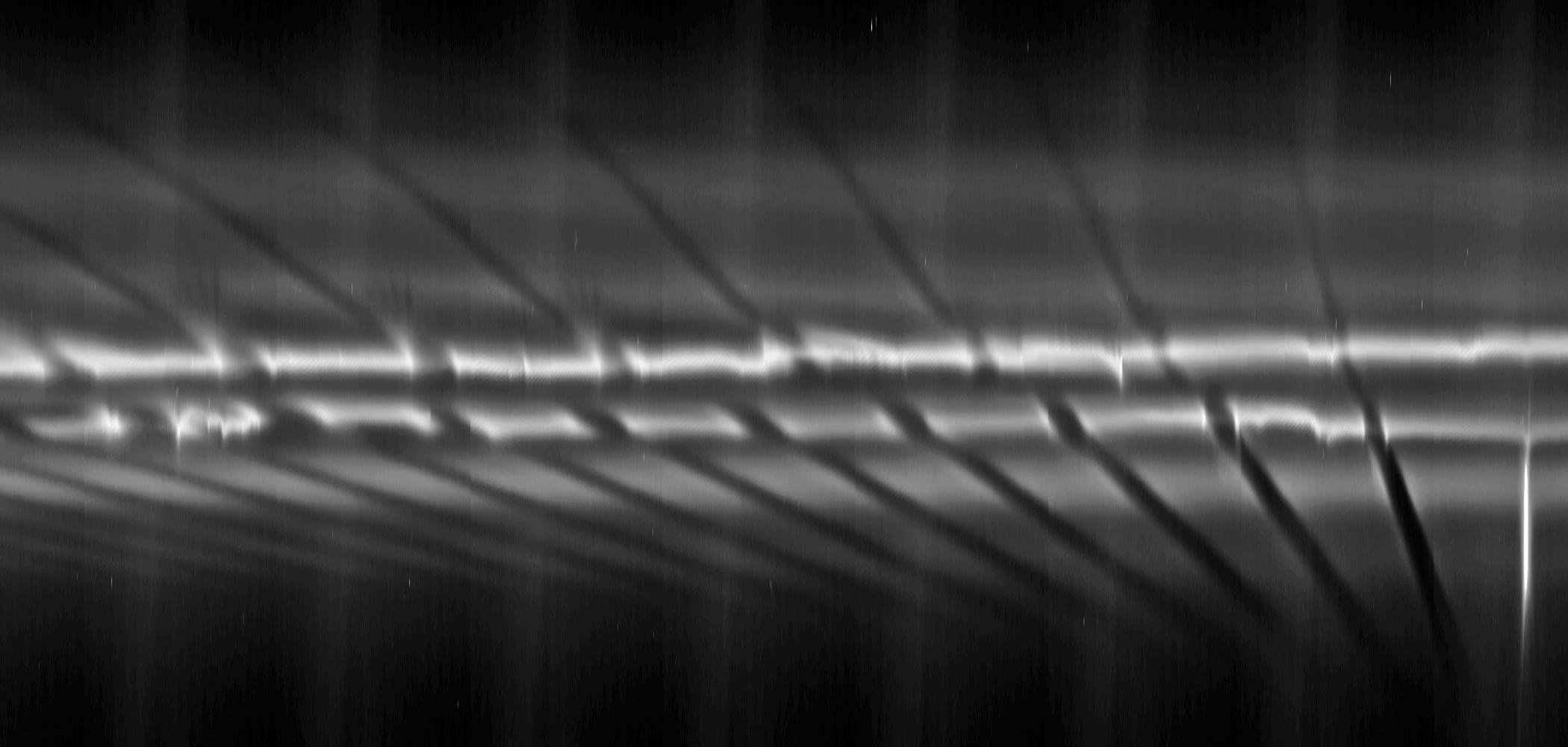 From right to left in the mosaic, each fan appears dark above the bright core of the F ring near the larger, diagonal channels created by the ring's shepherding moon Prometheus.