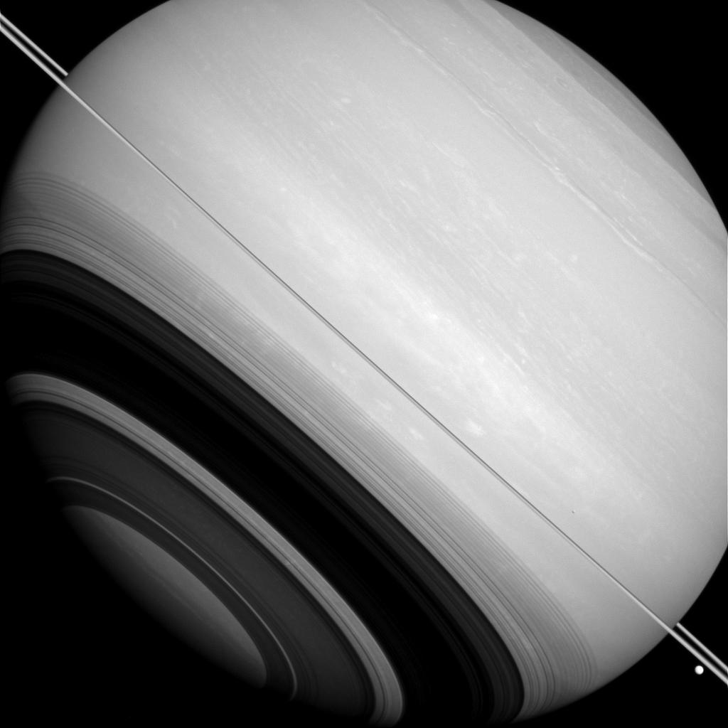 Saturn is circled by its rings, as well as by the moons Tethys and Mimas.
