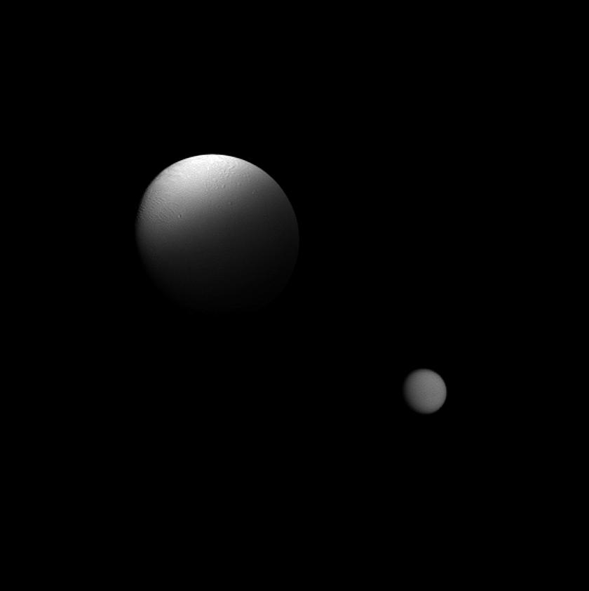 Saturn's moon Enceladus is partially eclipsed by the planet in this Cassini spacecraft view which also features the moon Titan in the distance.
