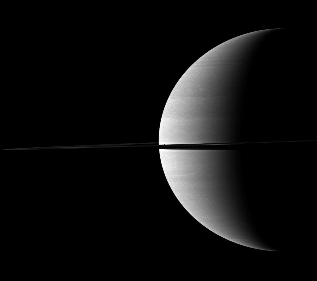 The diminutive moon Mimas can be found hiding in the middle of this view of a crescent of Saturn bisected by rings.