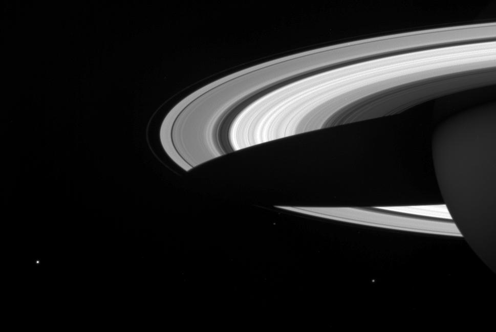 A string of three of Saturn's icy moons encircles the planet in this Cassini image