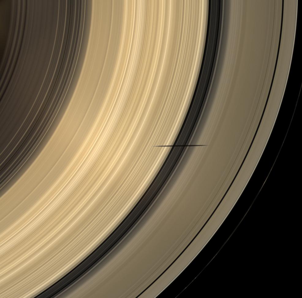 The shadow of Saturn's moon Mimas dips onto the planet's rings