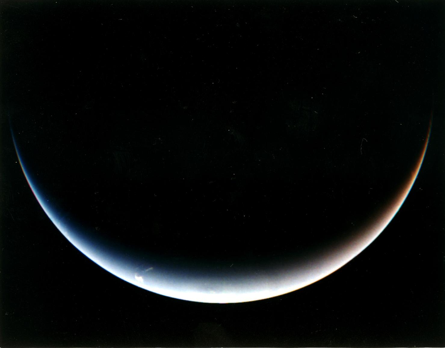 Voyager 2's post-encounter view of Neptune's south pole as the spacecraft sped away on a southward trajectory.
