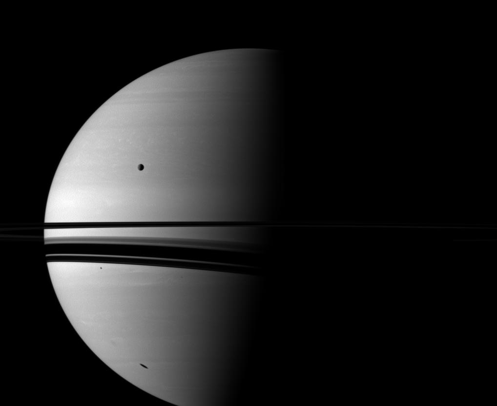 Shadows adorn Saturn in this Cassini spacecraft view, which also includes the moon Rhea.